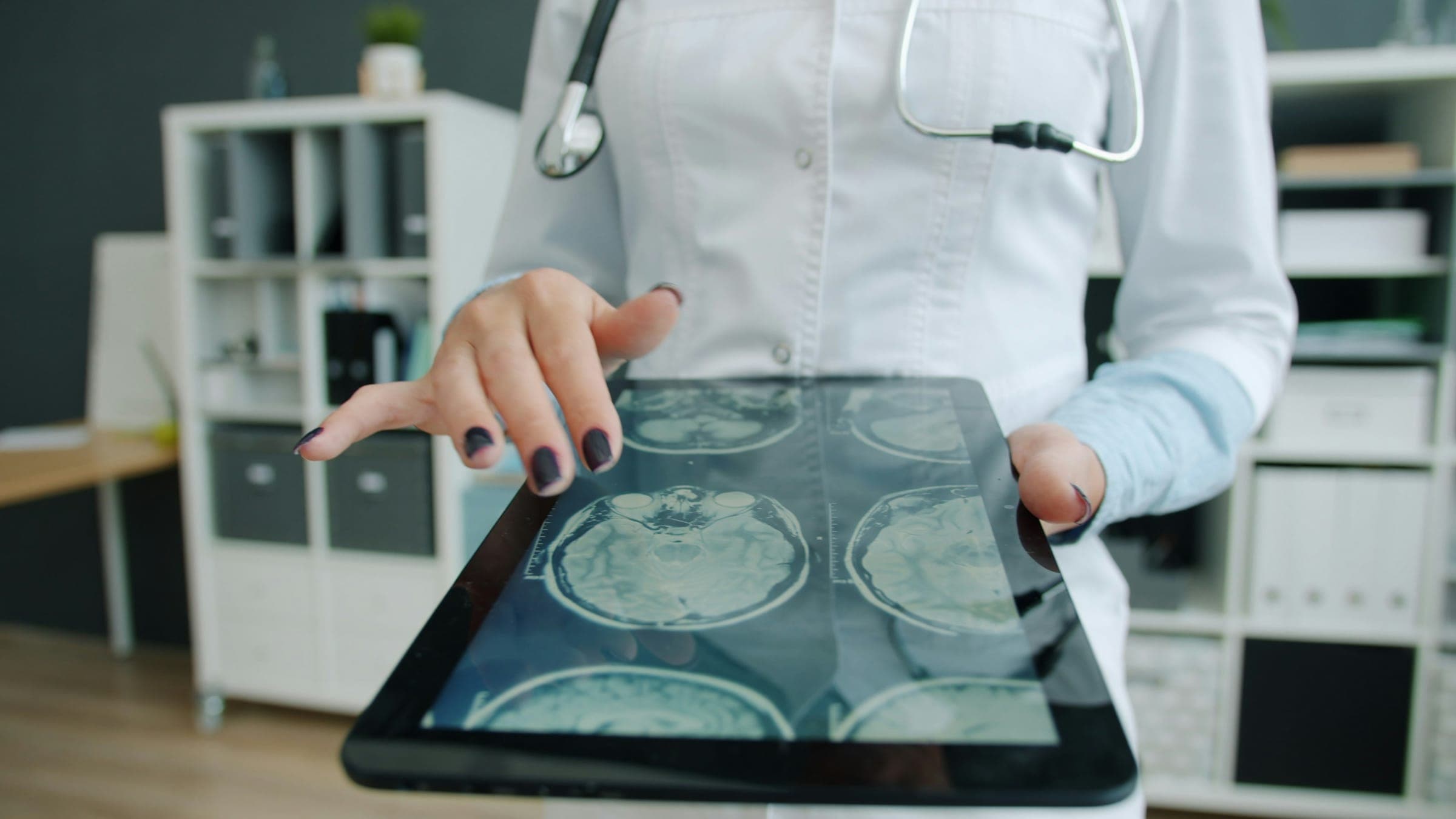 A clinician reviewing brain scans on a tablet